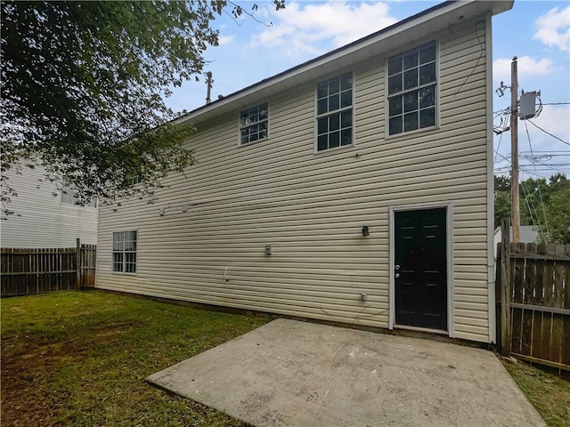 back of property featuring a yard and a patio area