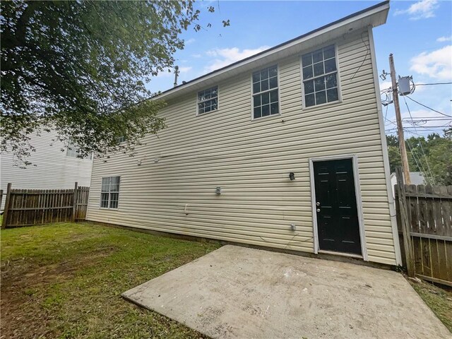 back of house featuring a patio and a lawn