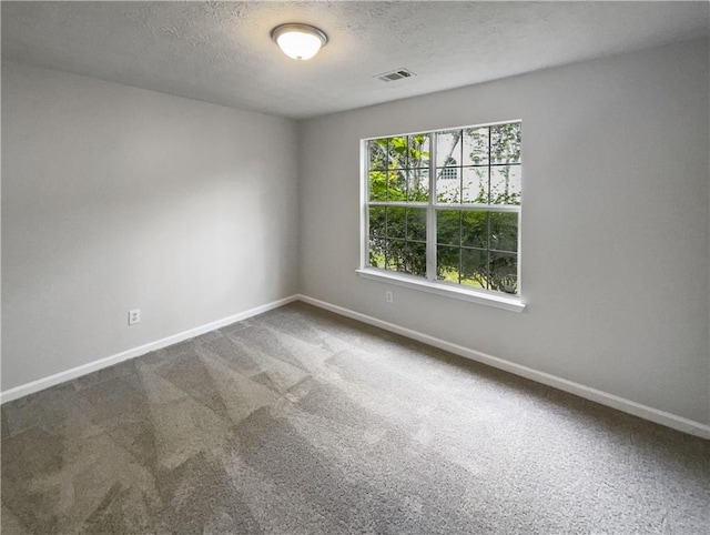 unfurnished room featuring carpet and a textured ceiling