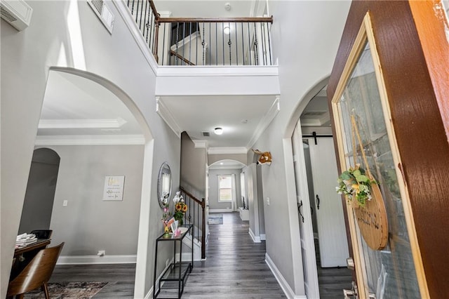 4850 Wilshire Xing, Cumming, GA 30040 - foyer entrance featuring arched walkways, wood finished floors, stairway, crown molding, and baseboards