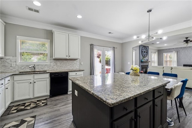 4850 Wilshire Xing, Cumming, GA 30040 - kitchen with black dishwasher, a sink, light wood-style flooring, a center island, and white cabinets
