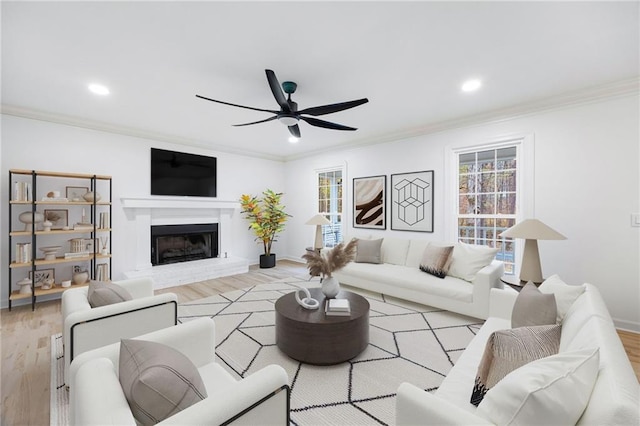 living room with crown molding, a healthy amount of sunlight, and light hardwood / wood-style floors