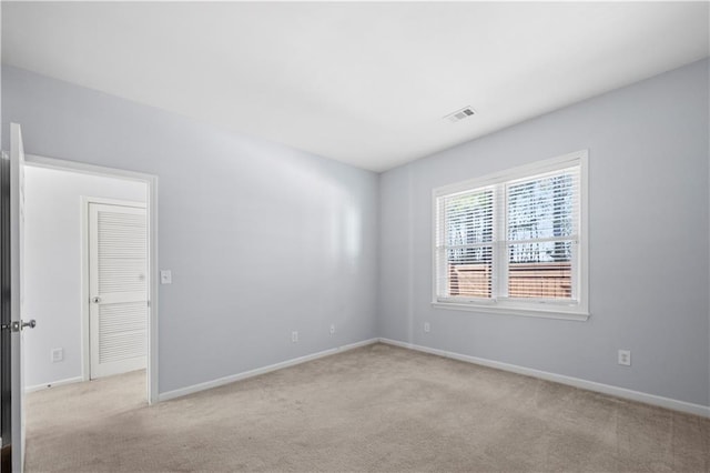 carpeted empty room featuring visible vents and baseboards