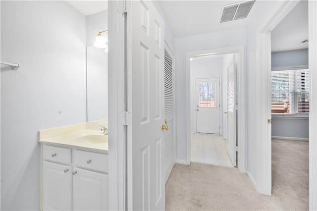 bathroom featuring vanity, baseboards, visible vents, and a wealth of natural light