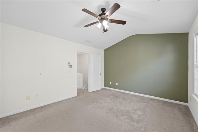 unfurnished bedroom featuring a ceiling fan, vaulted ceiling, carpet, and baseboards