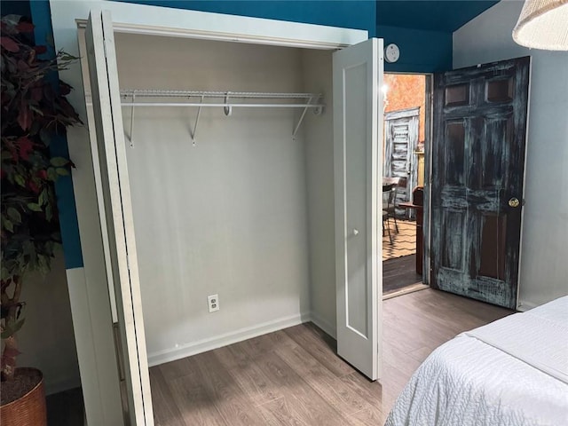 bedroom featuring baseboards and wood finished floors