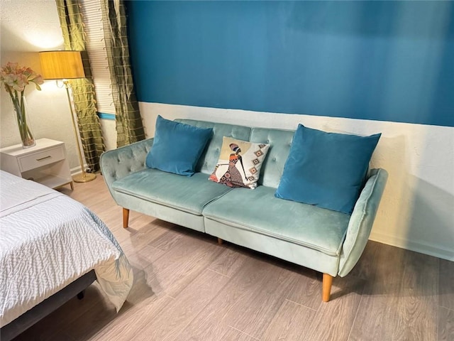 bedroom with baseboards and wood finished floors
