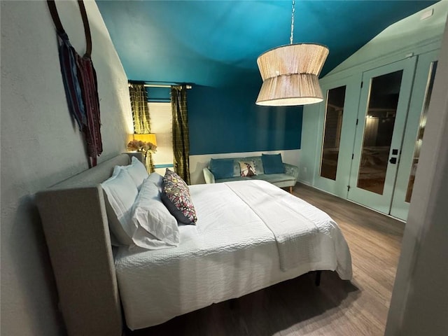bedroom with lofted ceiling and wood finished floors