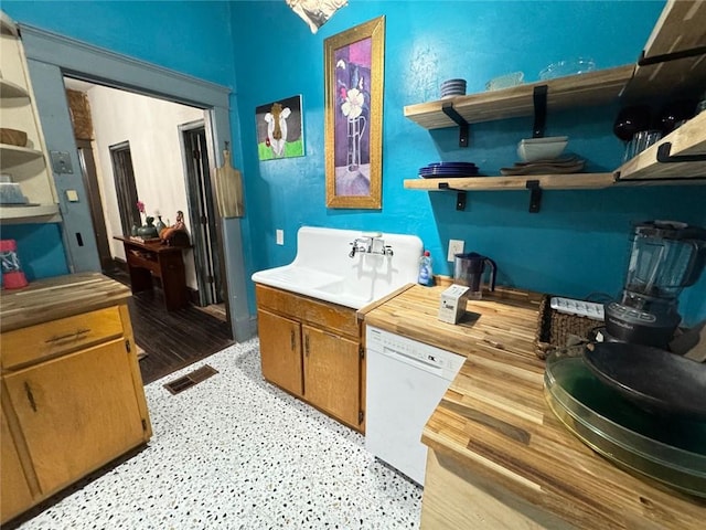 kitchen featuring visible vents, open shelves, dishwasher, a sink, and wooden counters
