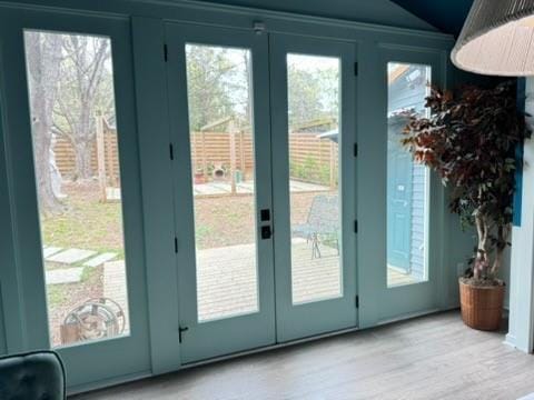doorway to outside with french doors, wood finished floors, and lofted ceiling