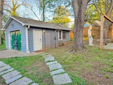 view of outbuilding featuring fence and an outbuilding