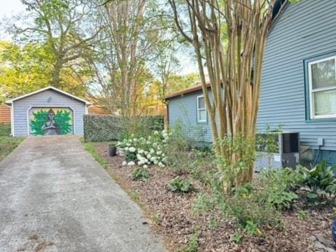 view of home's exterior featuring an outbuilding, a detached garage, and driveway