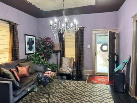 interior space featuring baseboards, a notable chandelier, and wood finished floors