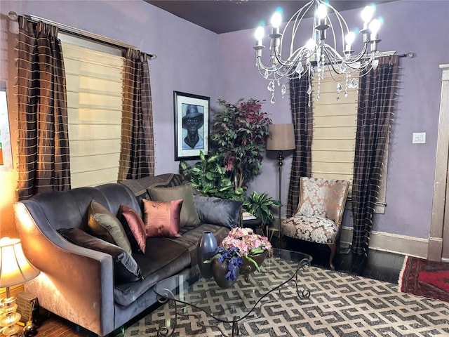 living area featuring baseboards, an inviting chandelier, and wood finished floors