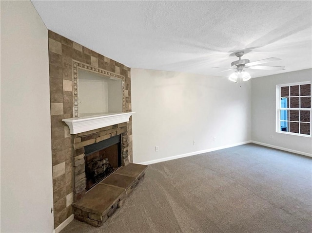 unfurnished living room featuring a textured ceiling, a fireplace, carpet flooring, and baseboards