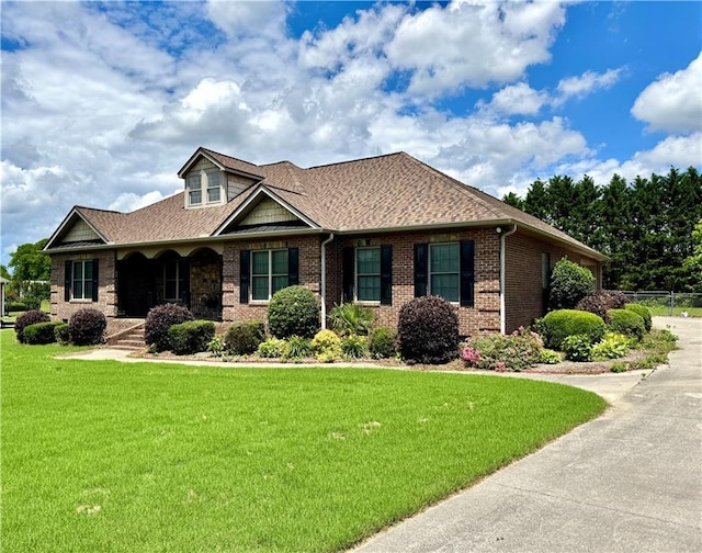 167 Techview Dr SW, Calhoun, GA 30701 - view of front facade featuring brick siding, a front yard, covered porch, and a shingled roof