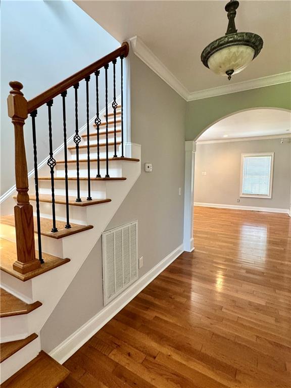 167 Techview Dr SW, Calhoun, GA 30701 - stairs featuring arched walkways, wood finished floors, crown molding, and baseboards