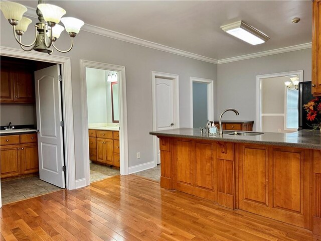 167 Techview Dr SW, Calhoun, GA 30701 - kitchen featuring a chandelier, brown cabinetry, light wood finished floors, crown molding, and a sink