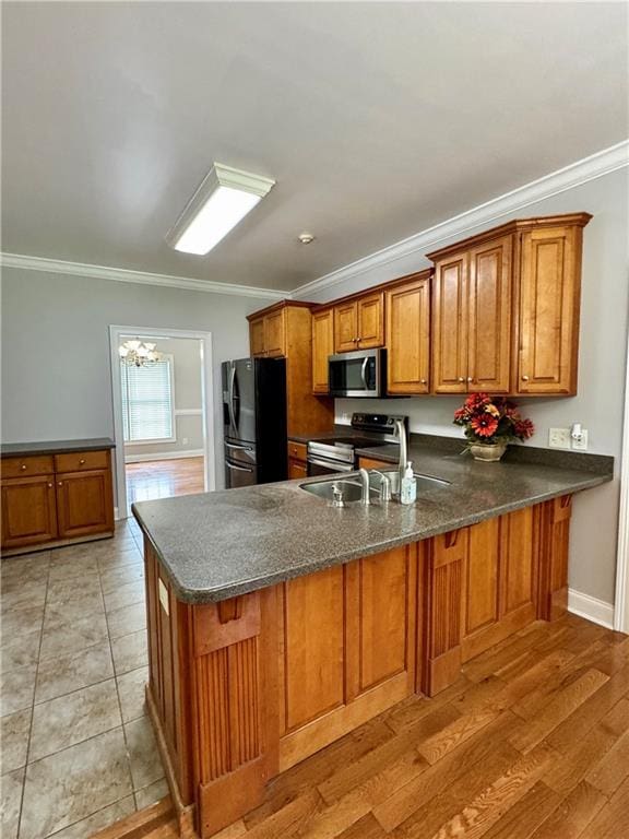 167 Techview Dr SW, Calhoun, GA 30701 - kitchen with stainless steel appliances, brown cabinetry, ornamental molding, a peninsula, and a chandelier