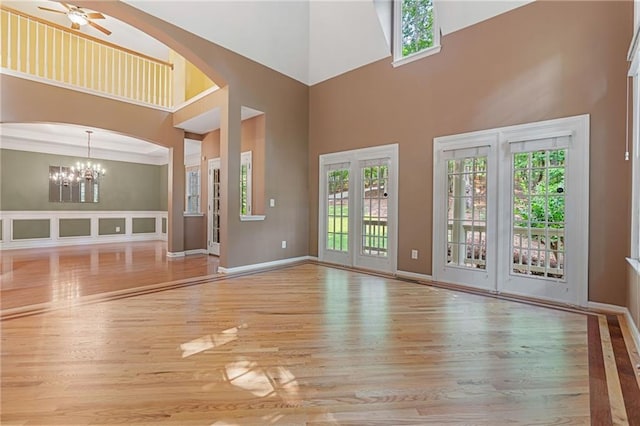 168 Eagle Pointe Dr, Dahlonega, GA 30533 - unfurnished living room featuring wood finished floors, ceiling fan, a towering ceiling, a chandelier, and baseboards