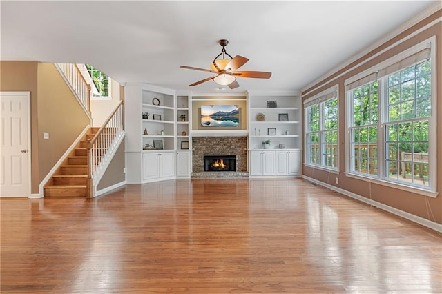 168 Eagle Pointe Dr, Dahlonega, GA 30533 - unfurnished living room with wood finished floors, ceiling fan, baseboards, stairs, and a glass covered fireplace