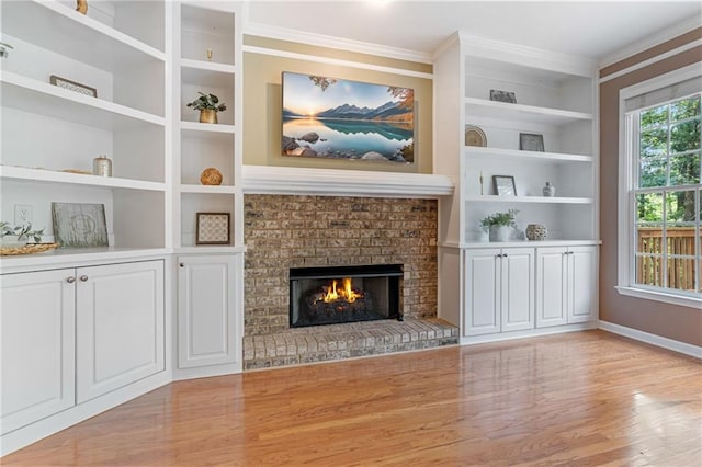 168 Eagle Pointe Dr, Dahlonega, GA 30533 - unfurnished living room featuring ornamental molding, light wood-type flooring, a brick fireplace, baseboards, and built in features