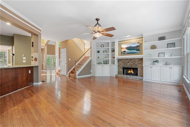 168 Eagle Pointe Dr, Dahlonega, GA 30533 - unfurnished living room with ceiling fan, baseboards, light wood-type flooring, stairs, and a glass covered fireplace