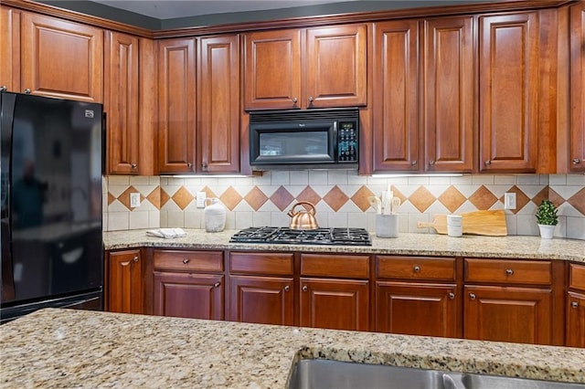 168 Eagle Pointe Dr, Dahlonega, GA 30533 - kitchen with black appliances, backsplash, light stone countertops, and brown cabinets