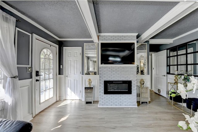 entryway featuring a fireplace, a textured ceiling, wood-type flooring, and plenty of natural light