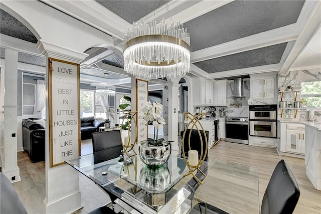 dining space featuring beam ceiling, ornamental molding, light hardwood / wood-style flooring, and an inviting chandelier