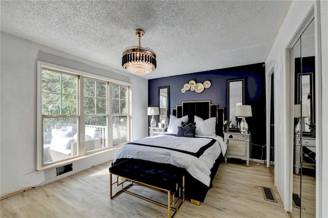 bedroom with a textured ceiling and light wood-type flooring