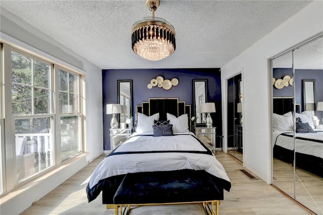 bedroom with a textured ceiling and light wood-type flooring