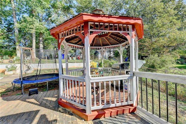 wooden terrace with a gazebo and a trampoline