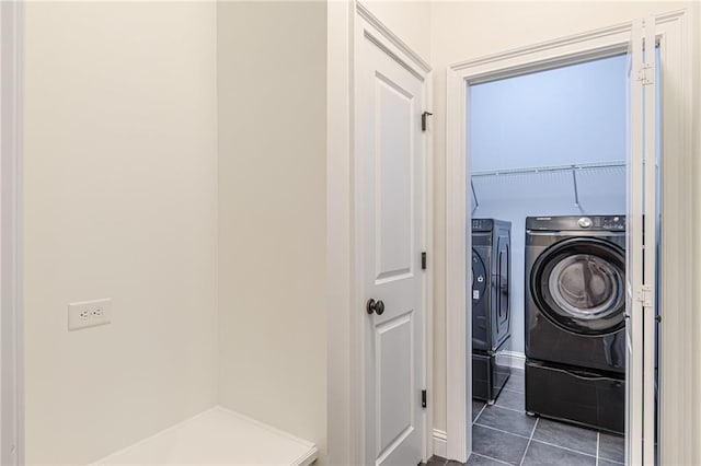 laundry room featuring dark tile patterned flooring and separate washer and dryer