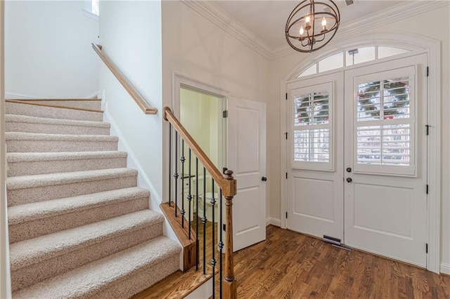 entrance foyer featuring a chandelier, crown molding, dark hardwood / wood-style flooring, and french doors