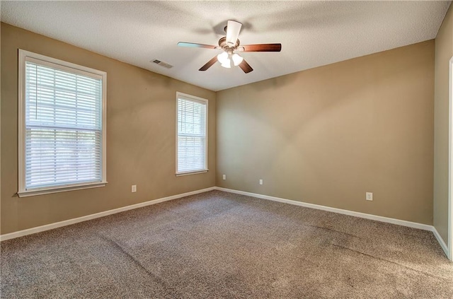 carpeted spare room with ceiling fan and a textured ceiling