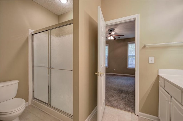 bathroom with vanity, a textured ceiling, toilet, and a shower with door