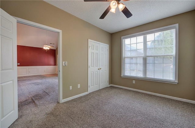 unfurnished bedroom featuring a textured ceiling, carpet floors, and ceiling fan