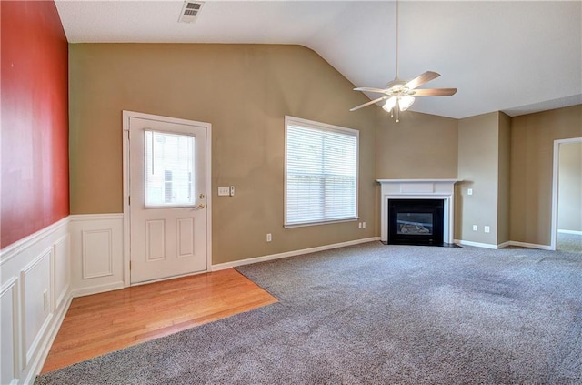 unfurnished living room featuring carpet floors, a wealth of natural light, and vaulted ceiling