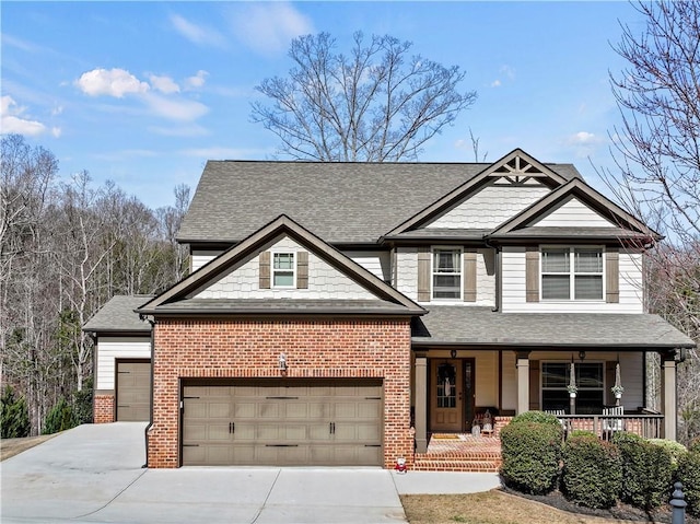 craftsman-style home featuring covered porch, brick siding, an attached garage, and concrete driveway