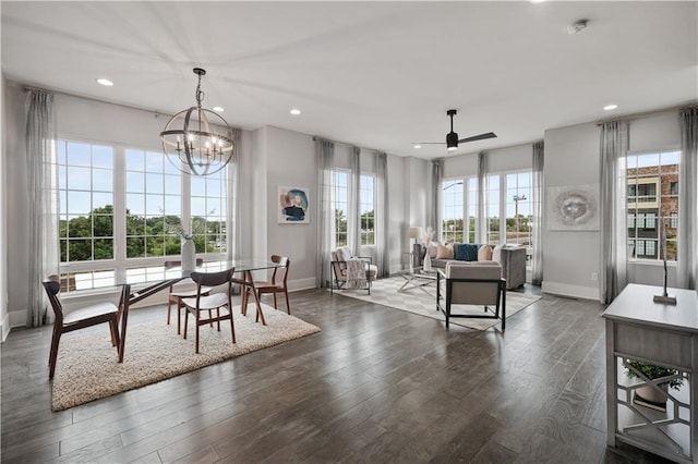 dining space featuring dark hardwood / wood-style flooring and ceiling fan with notable chandelier