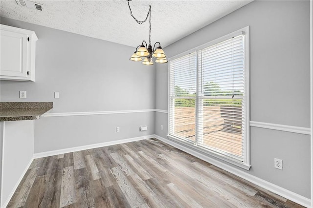 630 River Mill Rd, Bethlehem, GA 30620 - unfurnished dining area with a chandelier, wood finished floors, a textured ceiling, and baseboards