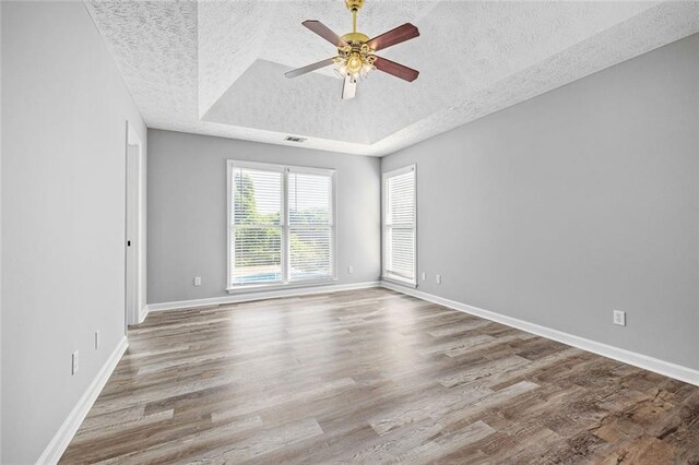 630 River Mill Rd, Bethlehem, GA 30620 - empty room featuring a textured ceiling, a raised ceiling, a ceiling fan, wood finished floors, and baseboards