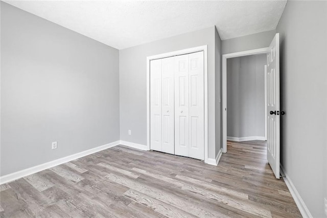 630 River Mill Rd, Bethlehem, GA 30620 - unfurnished bedroom with wood finished floors, a closet, baseboards, and a textured ceiling