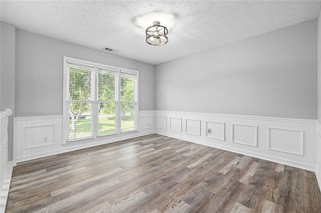 630 River Mill Rd, Bethlehem, GA 30620 - empty room with wainscoting, a textured ceiling, wood finished floors, and a decorative wall