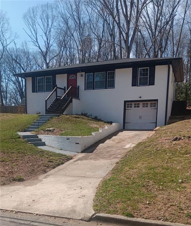 view of front facade with a garage, concrete driveway, and stucco siding