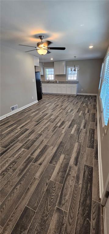 unfurnished living room featuring visible vents, dark wood-type flooring, recessed lighting, baseboards, and ceiling fan