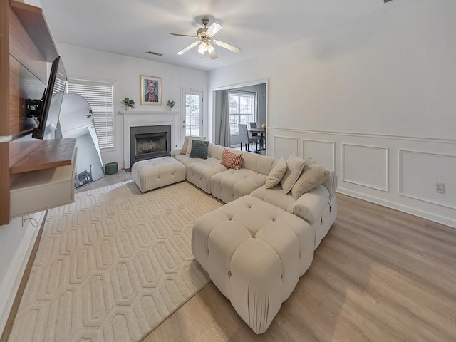 388 Oakhaven Way, Villa Rica, GA 30180 - living room with light wood-style flooring, ceiling fan, visible vents, a decorative wall, and a fireplace