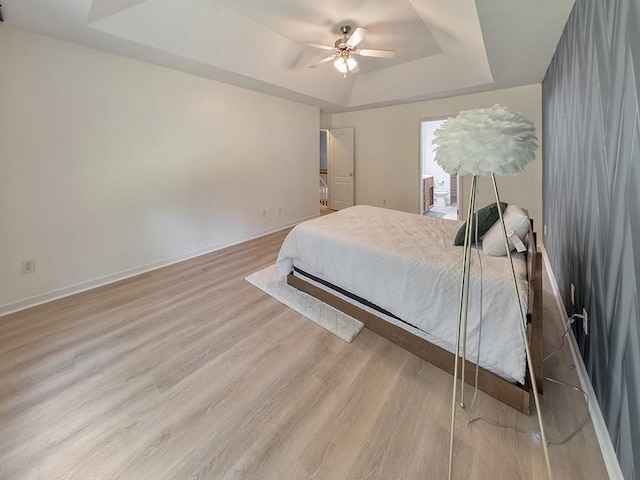 388 Oakhaven Way, Villa Rica, GA 30180 - bedroom featuring baseboards, a tray ceiling, light wood-style flooring, and ceiling fan