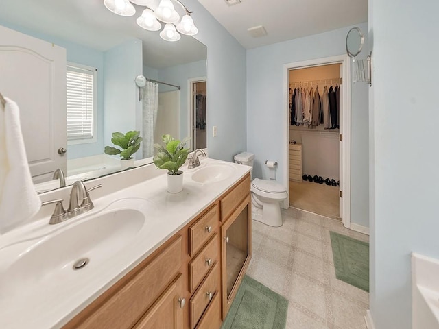 388 Oakhaven Way, Villa Rica, GA 30180 - bathroom with double vanity, a sink, tile patterned floors, and a walk in closet